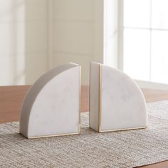 two white marble bookends sitting on top of a table