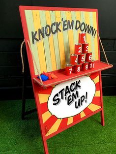 a stand with stacks of cups on it and a sign that says knock em down