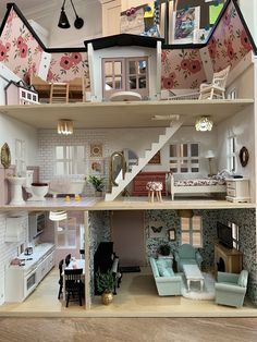 a doll house is shown with furniture and accessories on the top floor, as well as stairs leading up to the second floor