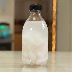 a bottle filled with white cotton sitting on top of a counter