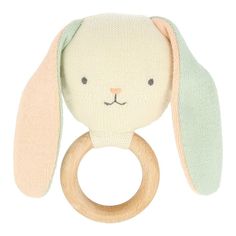 a white and green stuffed animal with a wooden ring on it's side,