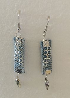 two pieces of fabric are attached to silver earwires, with beads and charms hanging from them