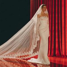 a woman in a wedding dress and veil on the catwalk at a fashion show