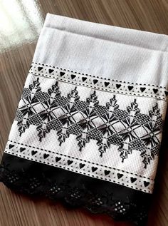 a piece of cloth with black and white designs on it sitting on top of a wooden table