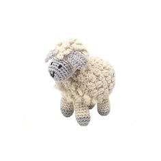 a crocheted sheep hanging from the ceiling in front of a white background,