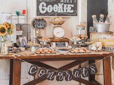 a table topped with lots of food next to a sign that says congratulations on it