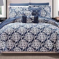 a blue and white comforter set with pillows