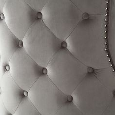 an upholstered headboard with buttons and pearls on the top, in grey velvet