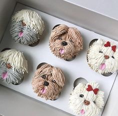 four cupcakes in the shape of dogs with bows