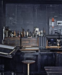 an old desk with many items on it and a blackboard in the back ground