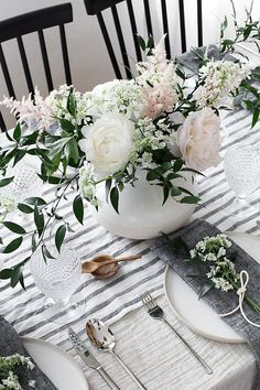 the table is set with flowers and silverware