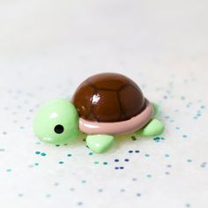 a small turtle figurine sitting on top of a white tablecloth covered floor