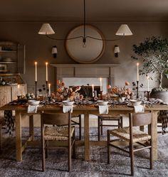 a dining room table is set with dishes and candles