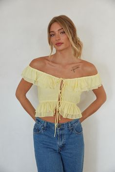 Light up the room in the Dorothea Ruffle Top! This cheery top features layers and layers of ruffles, delicate front bow detailing, and an off-the-shoulder neckline. Pair this summer top with your favorite denim to complete the look!Details: Self: 80% Rayon, 20% Nylon Lining: 100% Polyester Elastic neckline Tie front Fully lined Hand wash cold/ Line dry Jamaica Outfits, American Threads, Metallic Pants, Feminine Top, Trendy Boutique, Denim And Lace, Open Back Dresses, Ruffled Maxi Dress, Mini Dress Shop