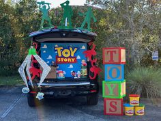 a toy story truck parked in a parking lot with toys on top of the back