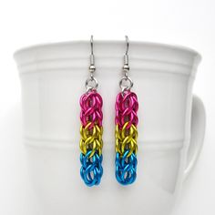 Show your pan pride with these stylish chainmail earrings! A short length of the full Persian weave was handwoven using anodized aluminum jump rings in the pansexual pride colors of pink, yellow and light blue.  Including the hypoallergenic stainless steel ear wires, these earrings measure approximately 2-3/8 inches in length. They are 3/8 inch wide. The current ear wires are surgical stainless steel French hooks, but can be switched to stainless lever backs, if you prefer. Please choose your ear wire style from the drop down menu when adding this item to your cart. Aluminum is a lightweight metal that will not tarnish or rust, and is easy to care for. The colors of anodized aluminum can be scratched by harder metals so take care when storing your earrings. I only use high quality saw cut Pansexual Earrings, Pansexual Bracelet, Chainmail Earrings, Pan Pride, Flag Earrings, Pride Jewelry, Pride Jewellery, Pride Colors, Pansexual Pride