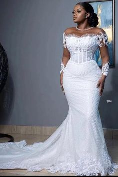 a woman in a white wedding dress posing for the camera