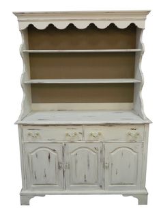 an old white painted china cabinet with scalloped top and drawers on one side