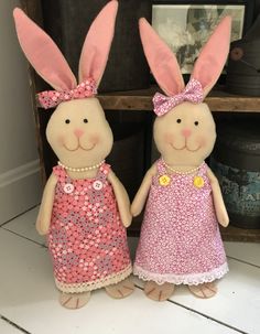 two stuffed rabbits are standing next to each other in dresses and headbands with sequins on them