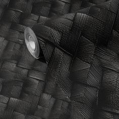 a close up of a black woven material with a light in the middle on it