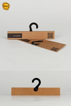 two cardboard hangers with black handles on them and one has a question mark in the middle