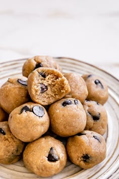 a pile of cookies sitting on top of a white plate next to a glass bowl