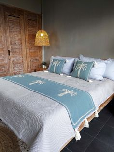 a bed with blue and white comforter in a bedroom next to a wooden door