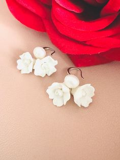 Skillfully crafted by hand, each earring showcases two delicate white clay flowers adorned with freshwater pearls. These exquisitely made flower bridal earrings are a perfect choice for your special day. 🖤 M A T E R I A L S  *  A N D  *  S I Z E  🖤 ❇️ MATERIAL & METAL: Brass- Clay Flower/Freshwater Pearl/Cubic Zirconia ❇️ METAL PLATING: Silver/Gold/Rose Gold ❇️ ESTIMATED SIZE: 3cm Length (Included Finish Post) ❇️ ESTIMATED WEIGHT: 8gram ❇️ QUANTITY: 1pair ❇️ LEAD-FREE & NICKEL FREE 🖤 A V A I L A B L E  *  F I N I S H 🖤 ❇️#1-CZ HOOP ❇️#2-CRYSTAL POST ❇️#3-PLAIN FISH HOOK ❇️#4-TEXTURE FISH HOOK ❇️#5-CLIP ON ❇️#6-PLAIN HOOP ❇️#7-CZ FISH HOOK ❇️#8-CZ FISH HOOK 🖤 C U S T O M I Z I N G  *  A N  *  E X I S T I N G  *  P I E C E 🖤 If you love this piece but feel you would like to make a few Adjustable White Jewelry With Flower Decoration, White Flower Earrings For Celebration, Handmade Flower-shaped Jewelry For Wedding, Traditional Flower Earrings For Wedding, Traditional Handmade Flower Earrings For Wedding, Traditional White Flower Earrings, Traditional Handmade Flower Jewelry For Wedding, Traditional Wedding Jewelry With Handmade Flowers, Adjustable Pearl White Flower-shaped Jewelry