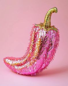 a pink and gold stuffed pepper on a pink background