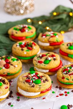 cookies decorated with candy and toppings are on a white surface next to christmas decorations