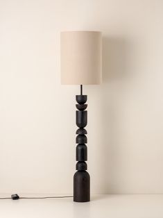 a lamp that is on top of a table next to a white wall and floor