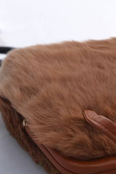 What a pretty vintage handbag, its covered in soft brown fur, with a contrasting strip of cream fur! This purse has two pockets inside, one zippered and one open. A deep caramel color trims the bag and handles. What a great gift! It would be wonderful with a vintage outfit, or just jeans and a white shirt! This handbag measures 9 inches high, 9 inches across, and about 3 inches wide, with the two interior pockets. There is no label inside. The handles have a 5 inch drop. For more lovely vintage Brown Rectangular Bag With Faux Fur Lining, Brown Shoulder Bag With Faux Fur Lining, Brown Faux Fur Lined Shoulder Bag, Brown Faux Fur Lined Tote Shoulder Bag, Brown Tote Shoulder Bag With Faux Fur Lining, Brown Rectangular Shoulder Bag With Plush Lining, Fluffy Brown Winter Bags, Brown Bags With Plush Lining For Winter, Brown Winter Bags With Plush Lining