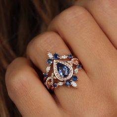 a woman's hand with a blue and white diamond ring on her finger,