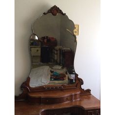 an antique dresser and mirror in the corner of a room