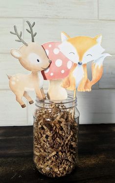 two deer and a fox are in a mason jar with some wood shavings