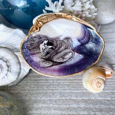 a shell with an image of a woman on it next to seashells