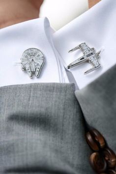 a close up of a person wearing a suit and tie with two pins on his lapel