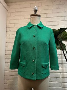 This 1960s jacket, crafted from vibrant Kelly green wool, captures the era's bold flair. Its tailoring, rich texture, and cute gold buttons offers a striking standout piece that embodies the lively spirit of the '60s. (Good Vintage Condition, has a few little tears but still great blazer)  Bust- 34" Waist- 34" Shoulders- 14" Sleeve- 16.5" Length- 20" Size: Extra small- small Retro Green Blazer For Workwear, Retro Green Blazer For Work, Retro Green Formal Outerwear, Vintage Green Outerwear With Snap Buttons, Green Vintage Outerwear With Snap Buttons, Retro Green Button-up Outerwear, Vintage Green Outerwear With Button Closure, Green Vintage Outerwear With Button Closure, Vintage Green Single Breasted Blazer