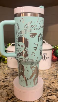 a cup with musical notes on it sitting on top of a counter next to other cups