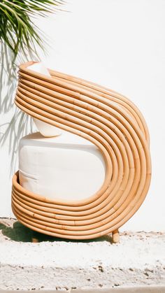 a wooden bench sitting on top of a white floor next to a palm leaf covered wall