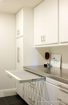 a kitchen with white cabinets and silver counter tops