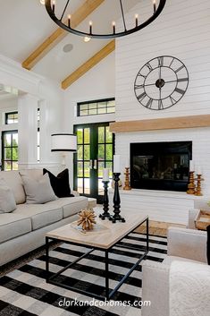 a living room filled with furniture and a large clock on the wall above the fireplace