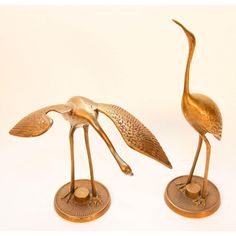 two brass birds standing on top of each other