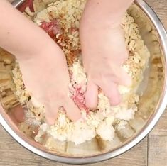 two hands reaching for food in a bowl