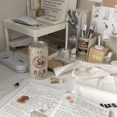 an office desk with various items on it and papers all over the place, including pens