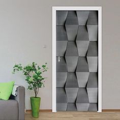 a living room with a gray couch and white door that has hexagonal design on it