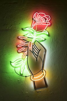 a neon sign with a hand holding a rose