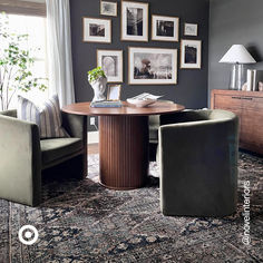 a living room filled with furniture and framed pictures on the wall above a round table