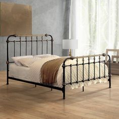 a metal bed frame in a bedroom with wood flooring