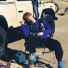 a woman sitting in a chair next to a truck